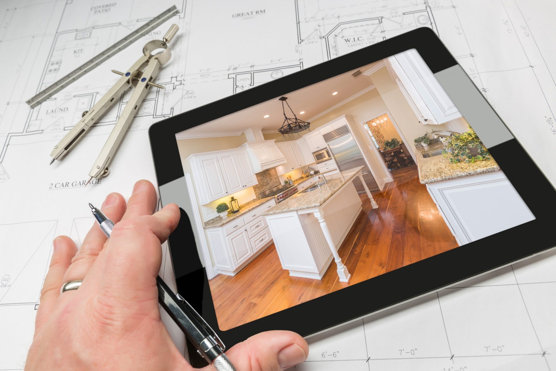 Hand of Architect on Computer Tablet Showing Custom Kitchen Photo Over House Plans