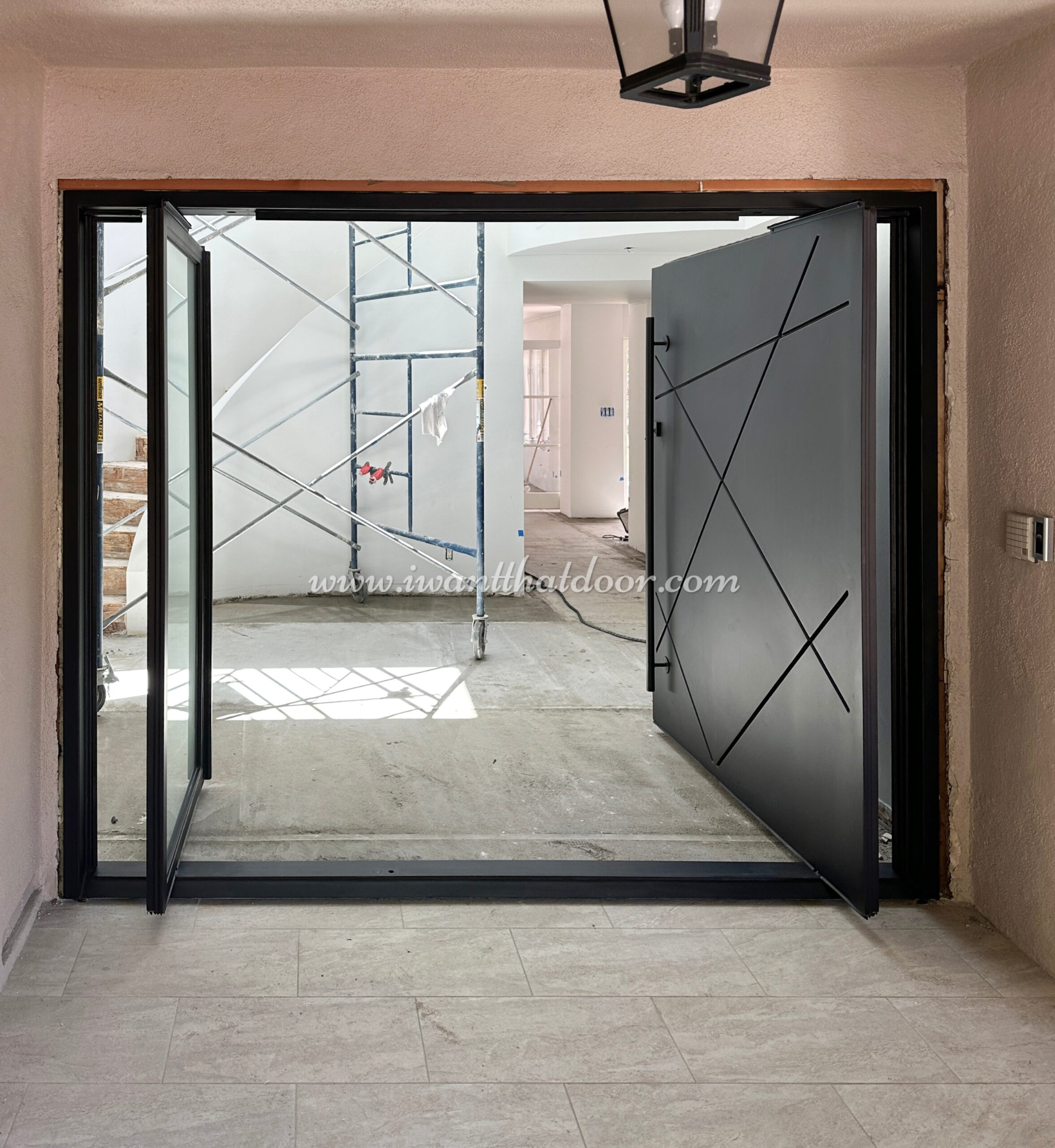 New construction home with a black pivot door from Universal Iron Doors